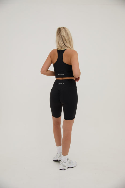 Women wearing high waisted black scrunch bum cycling shorts.